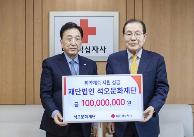 윤동한 석오문화재단 이사장(오른쪽)이 지난 26일 서울 중구 대한적십자사 서울사무소에서 성금 1억원을 전달한 뒤 김철수 대한적십자사 회장(왼쪽)과 기념 사진을 촬영하고 있다. 대한적십자사 제공
