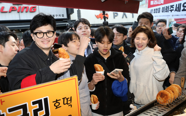 국민의힘 한동훈 비상대책위원장이 설 명절을 앞둔 2일 오후 경기도 구리시 구리전통시장을 방문해 호떡을 구입한 뒤 상인과 대화하고 있다. 연합뉴스