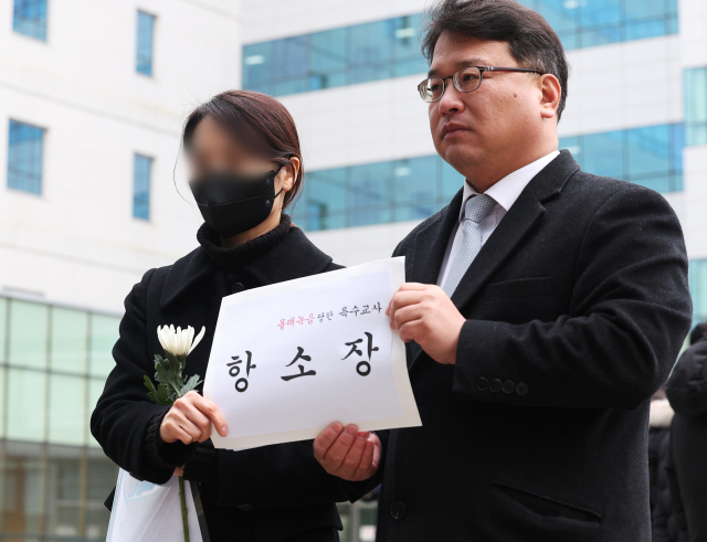웹툰 작가 주호민 씨의 아들을 정서적으로 학대한 혐의로 1심에서 유죄 판단을 받은 특수교사 A씨가 6일 오전 경기도 수원시 영통구 수원지방법원에서 항소장을 제출하고 있다. 1심 법원은 지난 1일 A씨에게 벌금 200만원의 선고를 유예했다. 연합뉴스
