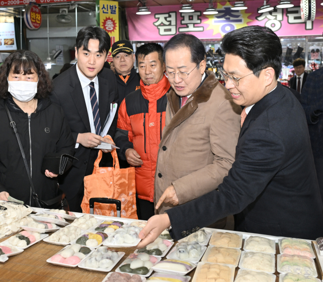 6일 오후 대구 팔달시장. 설맞이 장보기 행사에 나선 홍준표 대구시장이 매대에 진열된 상품을 확인하고 있다. 대구시 제공
