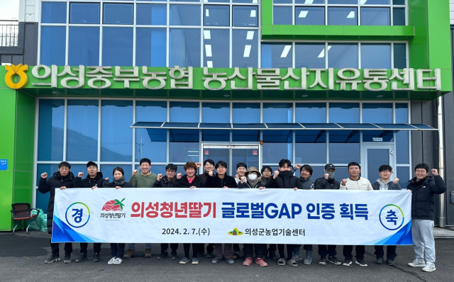 딸기 공선회 관계자들이 의성청년딸기의 글로벌 GAP 인증 획득을 축하하는 기념촬영을 하고 있다. 의성군 제공