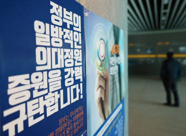 의료계에 따르면 지난 6일 정부가 2025학년도 의대 입학 정원을 2천명 늘리겠다고 발표한 후 전현직 대한의사협회(의협) 임원을 중심으로 정부를 규탄하는 발언이 잇따르고 있다. 한편 대한전공의협의회는 12일 온라인 임시총회를 열고 대응방안을 논의한다. 이날 서울 용산구 대한의사협회 회관에 증원 반대 포스터가 부착돼 있다. 연합뉴스
