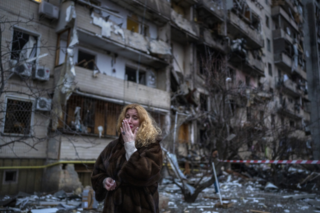 2022년 2월 25일 로켓 공격을 받아 벽면이 너덜너덜한 잔해물 더미로 변한 우크라이나 수도 키예프의 아파트 건물 앞에서 이곳에 살던 한 여성이 절규하고 있다.