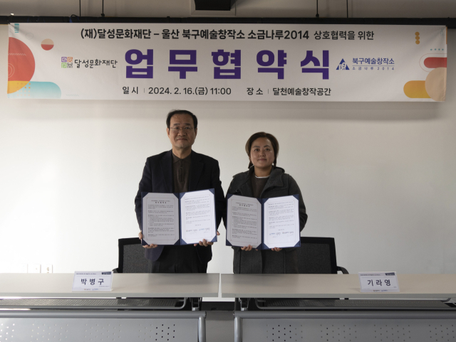 박병구(왼쪽) 달성문화재단 대표이사와 기라영 울산 북구예술창작소 소금나루2014 관장이 협약서를 들어보이고 있다. 달성문화재단 제공