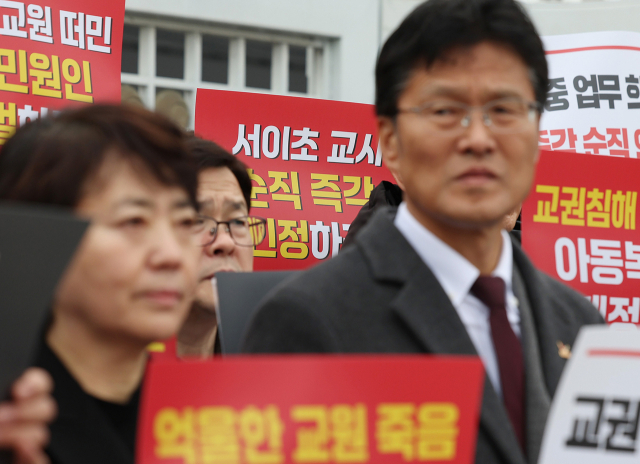 한국교원단체총연합회와 교사노동조합연맹·전국교직원노동조합 등 단체 회원들이 20일 오전 정부서울청사 앞에서 기자회견을 열고 지난해 숨진 서울 서이초 교사의 순직을 인정하고 관련 제도 개선을 촉구하는 손팻말을 들고 있다. 연합뉴스