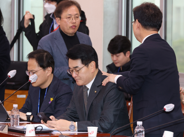 더불어민주당 박범계 의원이 20일 국회 법제사법위원회에서 전체회의 산회 후 박용진 의원의 어깨를 두드리며 인사하고 있다. 민주당은 박 의원에게 의정활동 평가 하위 10% 포함을 통보했다. 연합뉴스