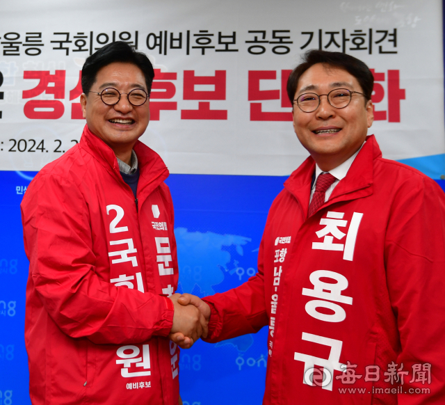 포항 남.울릉 선거구의 문충운(왼쪽), 최용규 예비후보가 단일화 선언 후 총선 승리를 다짐하며 서로 손을 맞잡고 있다. 신동우 기자