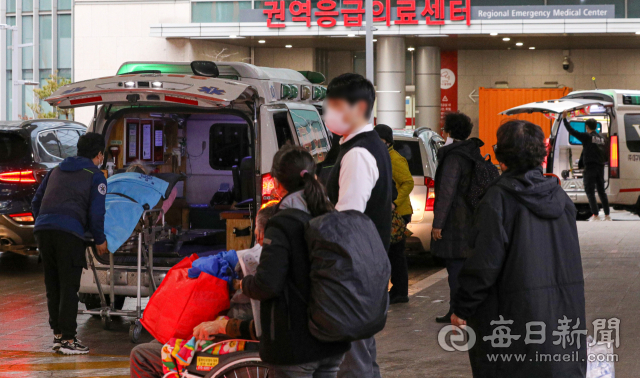 전공의 집단 사직으로 의료공백 이틀째를 맞은 지난 2월 대구의 한 대학병원에서 환자가 2차병원으로 전원을 하기 위해 보호자와 함께 대기 중인 구급차량으로 이동하고 있다. 매일신문 DB