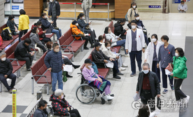 전공의 집단 사직으로 의료공백 이틀째를 맞은 21일 대구의 한 대학병원에서 진료를 보기 위해 대기하는 시민들 사이로 의료진이 이동하고 있다. 안성완 기자 asw0727@imaeil.com