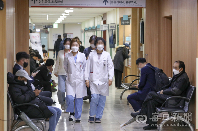 전공의 집단 사직으로 의료공백 이틀째를 맞은 21일 대구의 한 대학병원에서 진료를 보기 위해 대기하는 시민들 사이로 의료진이 이동하고 있다. 매일신문DB
