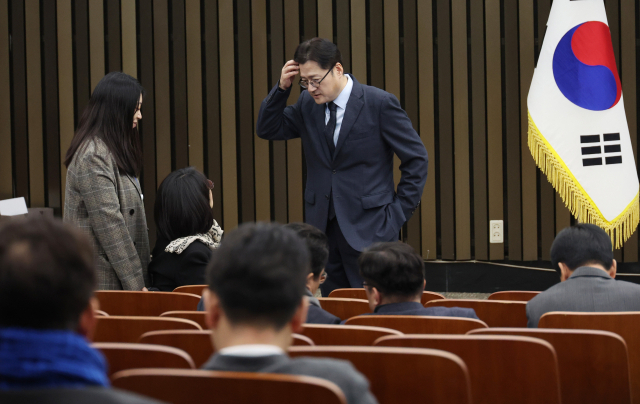 더불어민주당 홍익표 원내대표가 21일 국회에서 열리는 의원총회에서 동료 의원들과 대화하고 있다. 연합뉴스