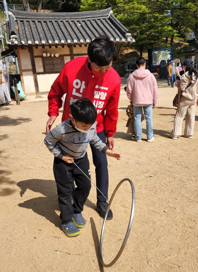 영남루에서 굴렁쇠를 굴리고 있는 아이와 함께. 안병구 밀양시장 예비후보사무실 제공