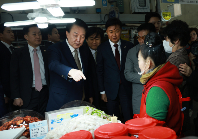 윤석열 대통령이 22일 경남 창원시 마산합포구 마산어시장을 찾아 젓갈가게에서 상인과 대화하고 있다. 연합뉴스