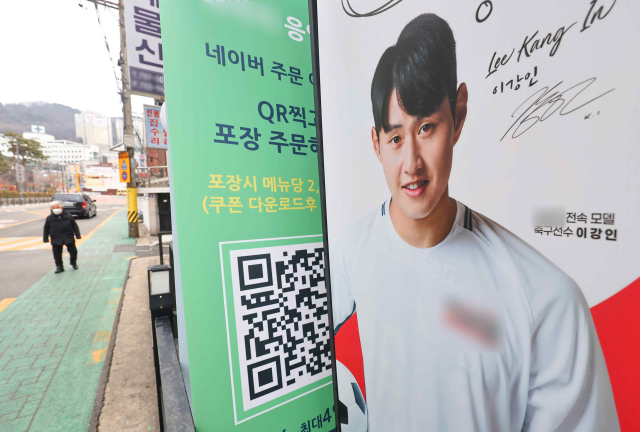 아시안컵 축구대표팀 선수 이강인이 주장 손흥민과 갈등을 빚은 사실이 알려지면서 이강인을 광고모델로 발탁한 기업들이 곤혹을 겪고 있다. 갤럭시 S24 프로모션 광고 모델로 이강인을 내세운 KT는 불매운동이 거론되는 등 비난 여론이 거세지자 프로모션을 조기 종료하는 수순에 들어가기도 했다. 사진은 18일 오전 서울 시내 한 음식점 앞에 설치된 이강인 광고물. 연합뉴스