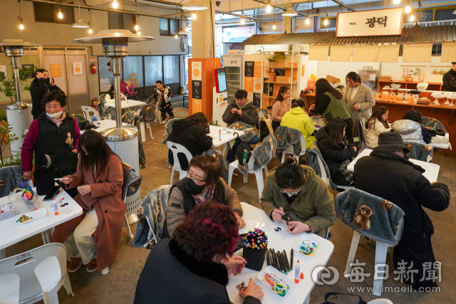 25일 대구 남구 광덕시장을 찾은 방문객들이 감성포차에서 이니셜 키링 만들기 체험을 하고 있다. 지난 23일 MZ세대의 감성을 담아 복합문화공간 