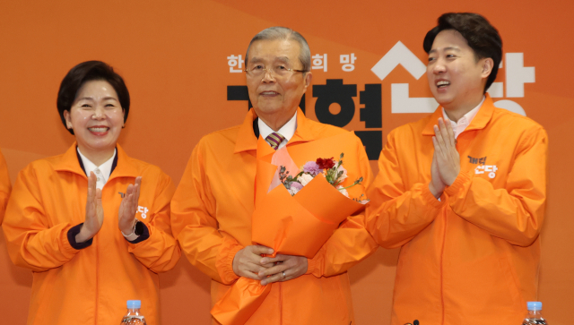 개혁신당 김종인 공천관리위원장이 26일 국회에서 열린 최고위원회의에서 꽃다발을 받고 있다. 왼쪽부터 양향자 원내대표, 김 위원장, 이준석 대표. 연합뉴스