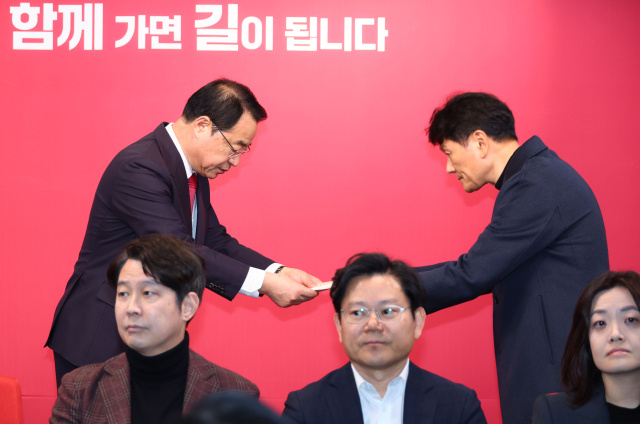 국민의힘 정영환 공천관리위원장이 25일 서울 여의도 당사에서 여론조사업체의 각 선거구 여론조사 결과를 전달받고 있다. 연합뉴스