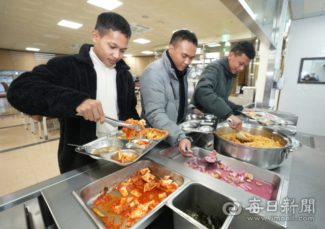 경북도교육청이 전국 최초로 해외에서 선발한 인도에시아 출신의 학생들이 27일 경북 영덕군 병곡면 해양수련원 급식실에서 볶음밥과 김치 등 한식을 맛 보기 위해 음식을 식판에 옮겨 담고 있다. 안성완 기자 asw0727@imaeil.com