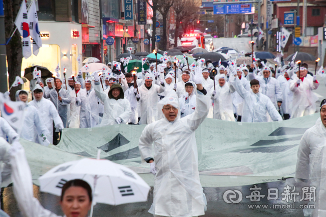3·1운동 전야인 29일 오후 광복회 안동시지회 주최로 열린 3·1절 재현 행사에 참가한 안동 시민들이 대형 태극기를 맞잡고 행진을 하고 있다. 안성완 기자 asw0727@imaeil.com