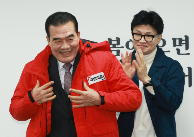 국민의힘 한동훈 비상대책위원장이 29일 오전 서울 여의도 국민의힘 중앙당사에서 열린 국민인재 영입 환영식에서 인재로 영입된구홍모 전 육군 참모차장에게 당 점퍼를 입혀주고 있다. 연합뉴스