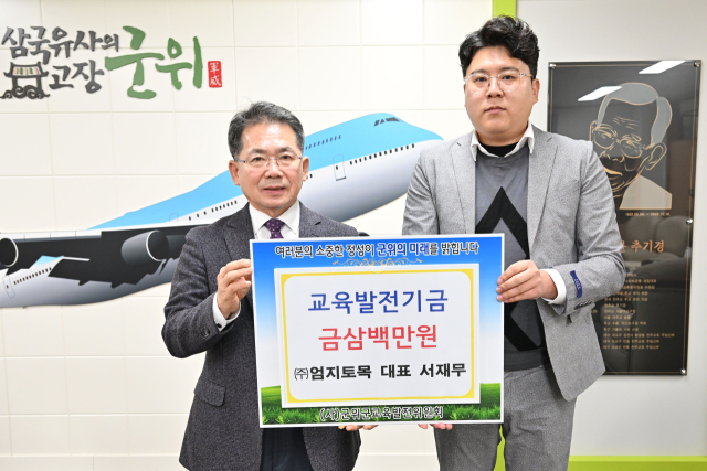 대구 군위군 서재무 ㈜엄지토목기술 대표가 군위군에 교육발전기금을 기탁하고, 김진열 군수와 기념 사진을 촬영하고 있다. 군위군 제공