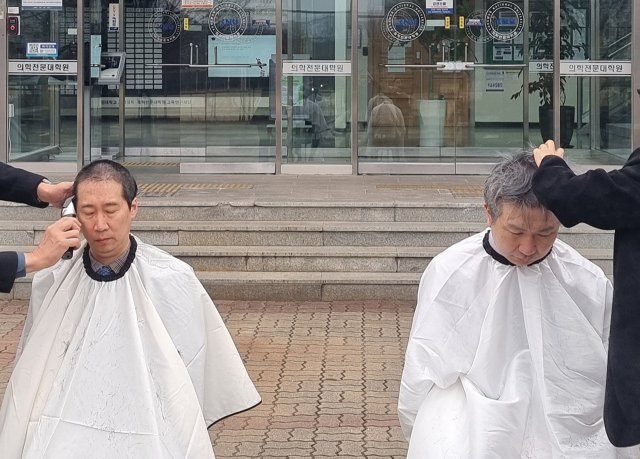 5일 오전 강원 춘천시 강원대학교 의과대학 앞에서 의대 교수들이 대학 측의 증원 방침에 반발하며 삭발하고 있다. 앞서 강원대는 교육부에 현재 49명에서 140명으로 의대 정원을 늘려달라고 요청했다. 연합뉴스