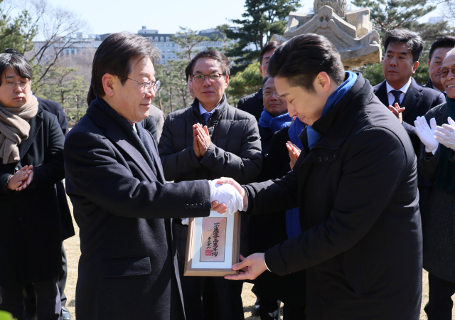 더불어민주당 이재명 대표가 1일 서울 효창공원 내 백범 김구 선생 묘역을 참배한 뒤 총선 영입 인재인 김용만 대한민국임시정부기념사업회 이사로부터 김구 선생의 휘호를 전달받고 있다. 연합뉴스