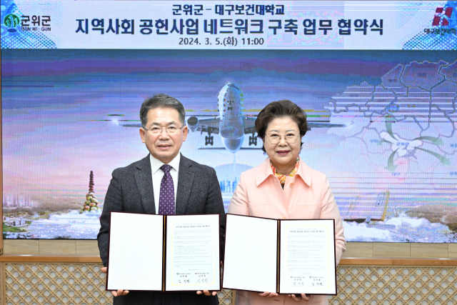 김진열(왼쪽) 대구 군위군수와 남성희(오른쪽) 대구보건대학교 총장이 경로당 프로그램 등을 통해 지역 문제를 해결하기 위한 업무 협약을 체결하고, 기념 사진을 촬영하고 있다. 군위군 제공