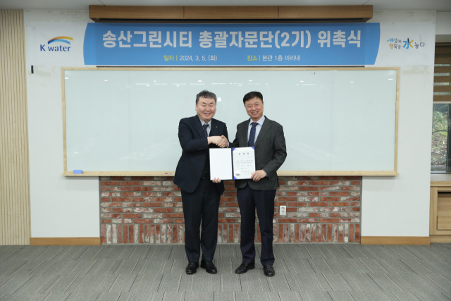 안정호 한국수자원공사 그린인프라부문장(사진 왼쪽)이 5일 송산그린시티 제2기 총괄자문단의 총괄기획가인 김찬호 중앙대 교수(사진 오른쪽)에 위촉장을 건네며 총괄자문단 출범을 기념하고 있다. 사진=한국수자원공사 제공