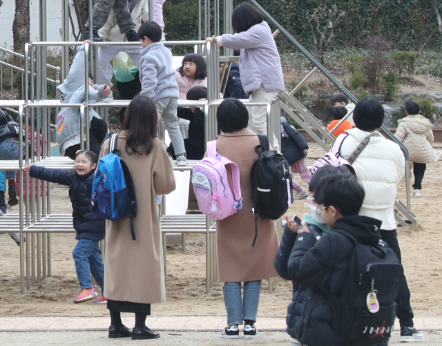 6일 오후 대구 수성구 동도초등학교에서 저학년 학생들의 하굣길을 마중 나온 부모들이 놀이터에서 놀고 있는 자녀들을 바라보고 있다. 안성완 기자 asw0727@imaeil.com