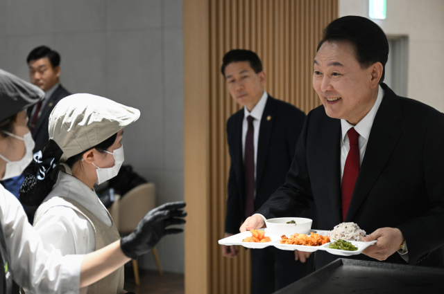 윤석열 대통령이 6일 오후 정부세종청사 중앙동 구내식당에서 교육부·보건복지부 공무원 격려 만찬에 참석해 구내식당 직원들과 인사하고 있다. 연합뉴스