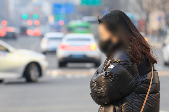 전국 대부분 지역에서 아침 기온이 영하권으로 떨어진 8일 오전 서울 광화문네거리에서 시민이 몸을 웅크린 채 횡단보도를 건너고 있다. 연합뉴스
