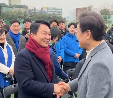 더불어민주당 이재명 대표와 국민의힘 원희룡 전 국토교통부 장관이 18일 오전 인천 계양구 계산체육공원 축구장에서 열린 계양축구협회 시무식에서 우연히 만나 악수하고 있다. 연합뉴스