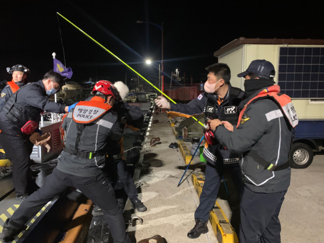 10일 오전 포항시 남구 모포항 앞바다에서 낫대에 이마가 찢겨 응급이송된 선원을 해양경찰관과 119구조대원들이 육지로 이송하고 있다. 포항해양경찰서 제공.