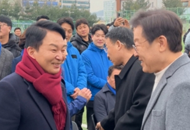 더불어민주당 이재명 대표와 국민의힘 원희룡 전 국토교통부 장관이 18일 오전 인천 계양구 계산체육공원 축구장에서 열린 계양축구협회 시무식에서 우연히 만나 악수하고 있다. 연합뉴스