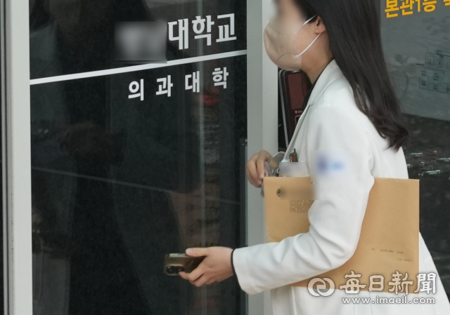정부가 서울대 의대 교수회의 집단사직 결정에 교수들의 진료유지 명령 검토 뜻을 밝힌 12일 대구의 한 대학교 의과대학으로 의료 관계자가 이동하고 있다. 안성완 기자 asw0727@imaeil.com