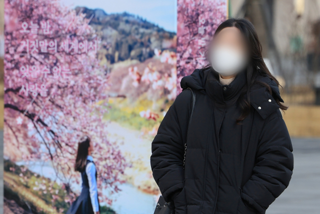 전국 대부분 지역에서 아침 기온이 영하권으로 떨어진 8일 오전 서울 광화문광장에서 두꺼운 옷을 입은 시민이 책 