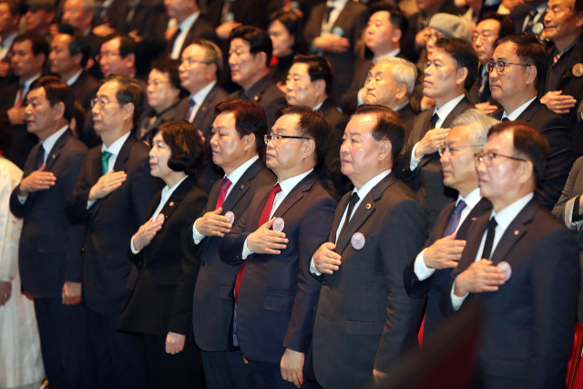 15일 경남 창원 3·15아트센터에서 거행된 제64주년 3·15의거 기념일 기념식에서 참석자들이 국민의례를 하고 있다. [사진=창원시]