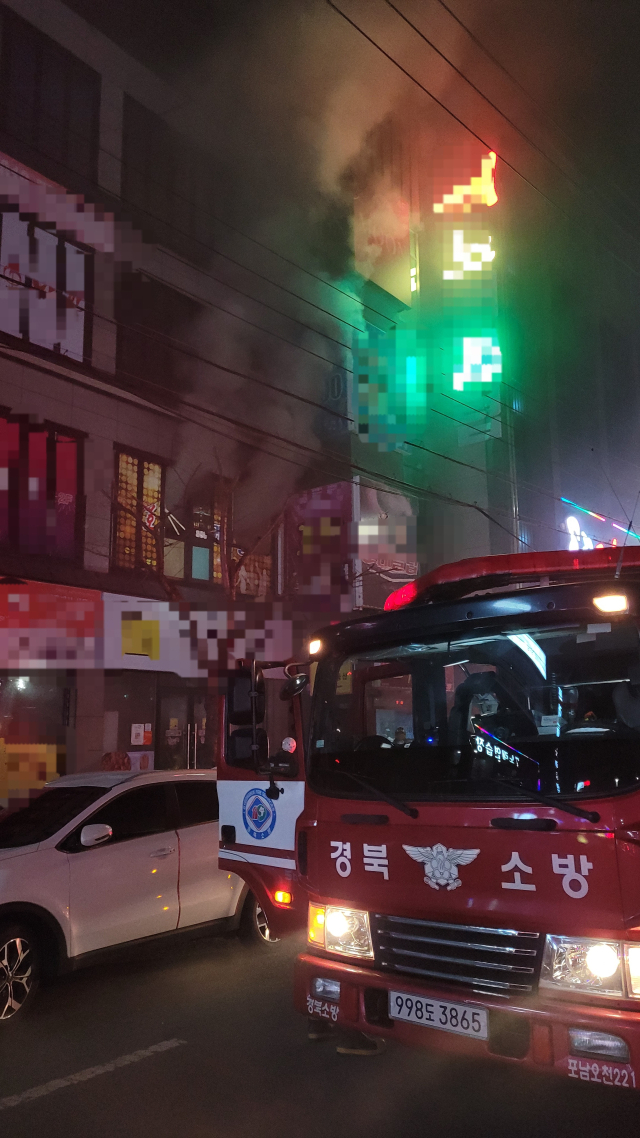 지난 15일 오후 포항시 남구 오천읍 한 노래클럽에서 발생한 화재를 소방대원들이 진화하고 있다. 경북소방본부 제공.