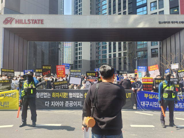 지난 16일 오후 대구 북구 고성동 힐스테이트 대구역 오페라 아파트 단지 정문 앞에서 입주예정자들이 집회를 열고 있다. 이정훈 수습기자