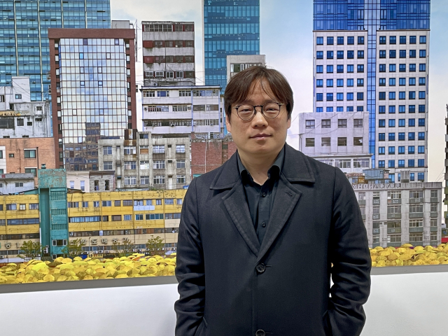장우진 작가가 자신의 작품 앞에서 포즈를 취하고 있다. 이연정 기자