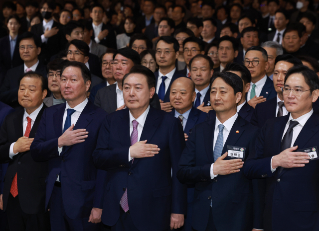 윤석열 대통령이 서울 영등포구 63컨벤션센터에서 열린 제51회 상공의 날 기념식에서 기업인들과 함께 국기에 경례하고 있다. 오른쪽 부터 이재용 삼성전자 회장, 안덕근 산업부 장관, 윤 대통령, 최태원 대한상의 회장. 연합뉴스