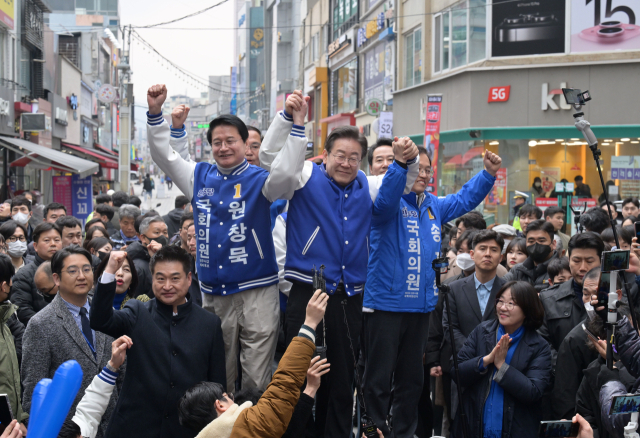 이재명 더불어민주당 대표가 19일 강원 원주 중앙시장을 방문해 원창묵, 송기헌 후보와 함께 단상에 올라 시민들에게 인사를 하고 있다. 연합뉴스