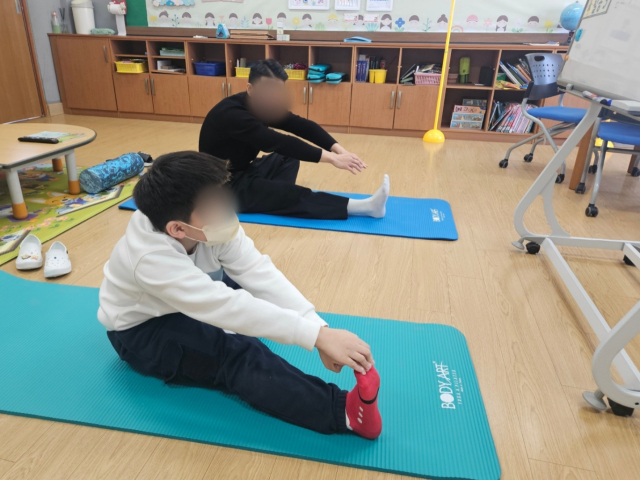 체육시간에 담임 선생님과 유연성 기르기 운동을 하고 있는 하준 군. 윤정훈 기자