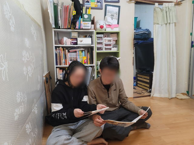 지난 22일 이정희(가명·50) 씨와 남편 이규호(가명·49) 씨가 딸이 그린 그림을 보며 생각에 잠겨있는 모습. 박성현 기자