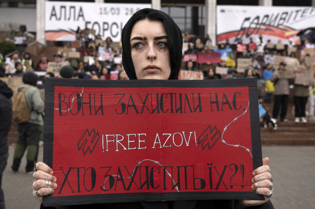 한 여성이 24일(현지시간) 우크라이나 키이우에서 러시아에 잡힌 포로를 도와달라며 플래카드를 들고 시위를 하고 있다. AP 연합뉴스