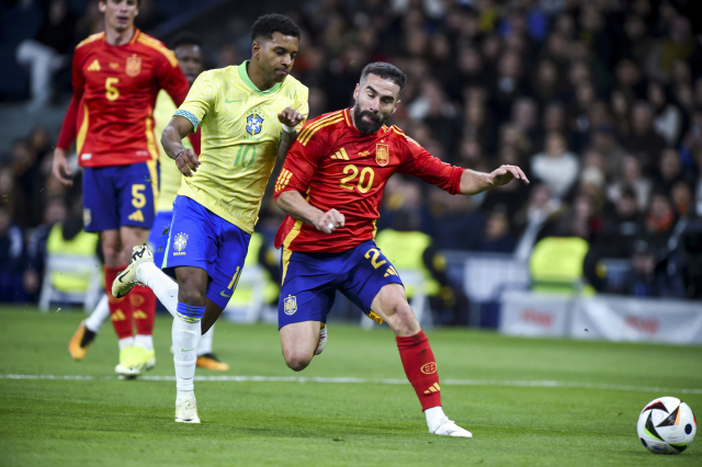 스페인의 다니엘 카르바할(20번)이 27일 스페인 마드리드의 산티아고 베르나베우에서 열린 친선 경기에 출전해 공을 향해 달리던 브라질의 호두리구를 막아서고 있다. 연합뉴스