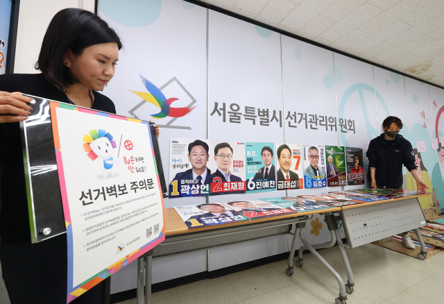 제22대 국회의원선거 선거벽보 제출 마감일인 27일 서울 종로구 선거관리위원회에서 관계자들이 각 후보의 선거벽보를 정리하고 있다. 연합뉴스