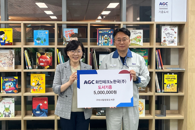 김춘경(오른쪽) AGC화인테크노한국 총무인사팀장이 이선임 구미시립도서관장에게 책을 기부한 뒤 기념촬영을 하고 있다. AGC화인테크노한국 제공