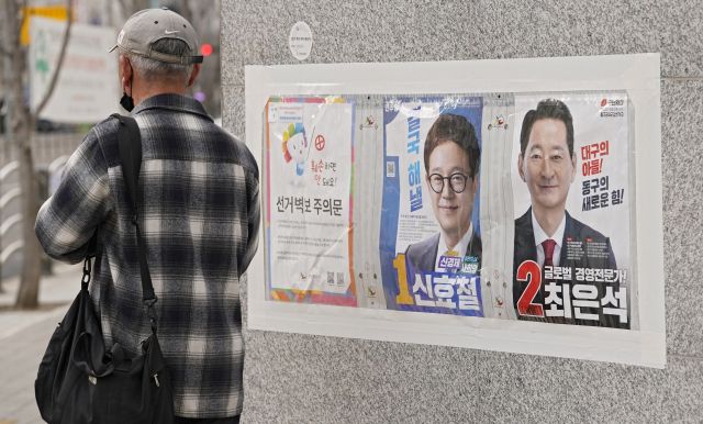 공식선거운동이 시작됐지만 대구경북은 역대 가장 조용한 총선이 예고된 대로 총선 열기가 살아나지 않고 있다. 31일 대구 동구 신암동에 첩부된 동구군위갑 출마자 벽보 앞을 시민이 무심히 지나고 있다. 김영진 기자 kyjmaeil@imaeil.com
